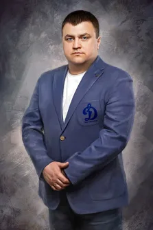 Портрет русоволосого мужчины в синем пиджаке и белой футболке на абстрактном фоне в тёмных тонах выполнен в стиле Под масло, художник Анастасия 