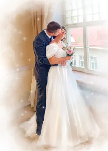 Парный портрет в стиле акварель. На картине запечатлена свадебная пара: жених в тёмном костюме нежно обнимает и целует невесту в щёку. Невеста в элегантном белом платье с короткими рукавами держит букет нежно-розовых роз, а солнечный свет, льющийся через большое окно, создаёт вокруг них атмосферу волшебства и радости. Художник Евгения