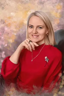Женский портрет под масло. На портрете изображена женщина с прямыми светлыми волосами, одетая в ярко-красный свитер с брошью в виде розы; она мягко улыбается, подперев подбородок рукой, украшенной крупными кольцами. Фон выполнен в пастельных тонах с размытыми золотисто-розовыми акцентами, создающими тёплую и элегантную атмосферу. Художник: Александра 