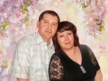 Парный портрет под масло. На картине изображён мужчина в светлой клетчатой рубашке и женщина в чёрном наряде с кружевными рукавами стоят рядом, слегка наклонившись друг к другу. Фон выполнен в нежных пастельных тонах с изображением цветущих ветвей, создающих романтичную и тёплую атмосферу. Художник Анна 