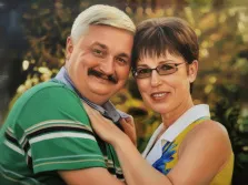 Парный портрет в стиле под масло. На картине изображена улыбающаяся пара — мужчина с седыми волосами и усами в зелёной полосатой рубашке и женщина в жёлтом платье с синим цветочным узором, в очках; она нежно обнимает мужчину за шею. Фон размытый, с тёплыми золотисто-зелёными оттенками, создающими атмосферу уюта и гармонии. Художник Александра