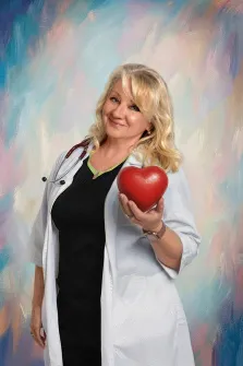 Женский портрет в стиле под масло. На картине изображена улыбающаяся женщина в белом медицинском халате со стетоскопом, держащая в руке большое красное сердце. Фон выполнен в мягких пастельных тонах с размытыми мазками, создающими лёгкую и позитивную атмосферу. Художник Ирина