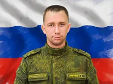 Мужской портрет в стиле под масло. На картине изображён военнослужащий в камуфляжной форме Вооружённых сил России, на груди которого видны нашивки с надписями «Вооружённые силы России» и «Дмитриев В. В.». На фоне развевается триколор — государственный флаг Российской Федерации, подчёркивающий патриотическую тематику изображения. Художник Анастасия