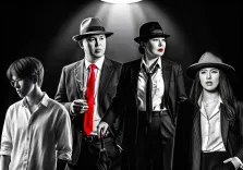 Семейный портрет в стиле под масло. На картине изображены четыре персонажа в стиле гангстерской эстетики: двое мужчин и две женщины в строгих костюмах, фетровых шляпах и с серьёзными выражениями лиц. Центральный мужчина выделяется ярким красным галстуком и сигаретой в руке, остальные фигуры выполнены в чёрно-белой гамме, а драматичный свет прожектора создаёт атмосферу нуарного кино. Художник  Анастасия