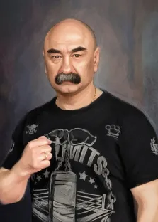 Мужской портрет под масло. На портрете изображён лысый мужчина с густыми тёмными усами и выразительными бровями, одетый в чёрную футболку с графическим принтом, изображающим боксёрскую грушу, очки и различные символы; его поза с поднятым кулаком придаёт образу решительность и силу. Фон выполнен в приглушённых серо-синих тонах, подчёркивая серьёзность и харизматичность персонажа. Художник: Александра