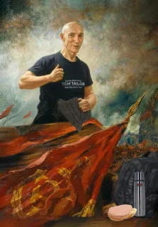 Мужской портрет в образе Ленина. На картине изображён улыбающийся мужчина в чёрной футболке с надписью «TOM TAILOR», который показывает жест «палец вверх» и держит в руке шляпу. На переднем плане видны красный флаг с советской символикой, чёрный рюкзак, термос и бутерброд, а фон выполнен в драматичных, размытых тонах с элементами городского пейзажа. Художник Ирина