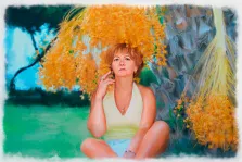Женский портрет в стиле Акварель с прорисовкой фона экзотической природы: коротко стриженная рыжеволосая женщина в майке и шортах сидит, скрестив ноги, под цветущей пальмой, правой рукой придерживая яркие оранжевые соцветия. Художник Мария.