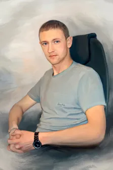 Мужской портрет Под масло, молодой человек в серой футболке и с часами на запястье сидит в кресле на нейтральном сером фоне, художник Анастасия 