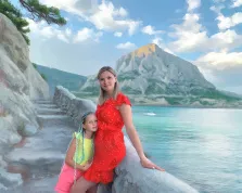 Семейный портрет мамы с дочкой, женщина блондинка в красном платье и девочка в жёлтой майке и в розовых шортах на фоне моря, работа исполнена маслом, художник Софья 