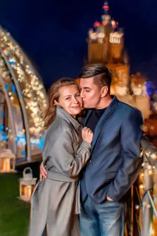 Парный портрет в стиле под масло, молодой человек в синем пиджаке и чёрной водолазке целует русоволосую девушку в сером пальто, на фоне ночная Москва, художник Александра 