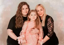 Семейный портрет на три персоны обрисован Под масло, кареглазая девушка с волнистыми волосами и светловолосая женщина держат на руках девочку в розовом платье, художник Софья 