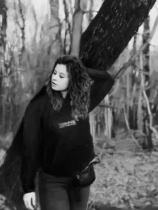 Портрет выполнен в чёрно-белых тонах на заказ под масло, девушка в кофте стоит возле дерева, художник Анастасия 