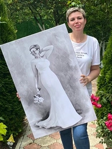 Женщина держит в руках собственный портрет на холсте карандашом, где она изображена в белом платье и с букетом цветов