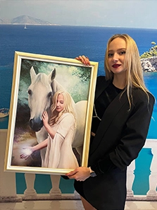 Девушка с собственным портретом на холсте в рамке, на котором она изображена вместе с лошадью