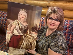 Женщина в очках держит подарок — портрет на холсте, выполненный по её фотографии в образе королевы