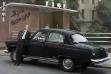 В образе, художник Антонина, мужчина рядом с черной машиной ГАЗ-21 на фоне кафе "Три тополя"