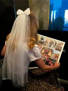 Пример печати на холсте: семейный фотоколлаж на стене, который рассматривает девочка