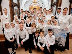 Группа в храме держит фотомозаику с изображением церкви