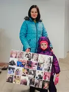 Семейный фотоколлаж в подарок Женщина с ребёнком держат большой семейный коллаж из фотографий